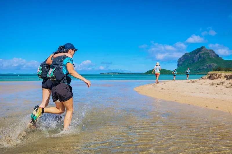 female-participants-running-along-a-tropical-beach-in-mauritius-during-femina-adventure--combining-fitness--nature-and-island-adventure..webp