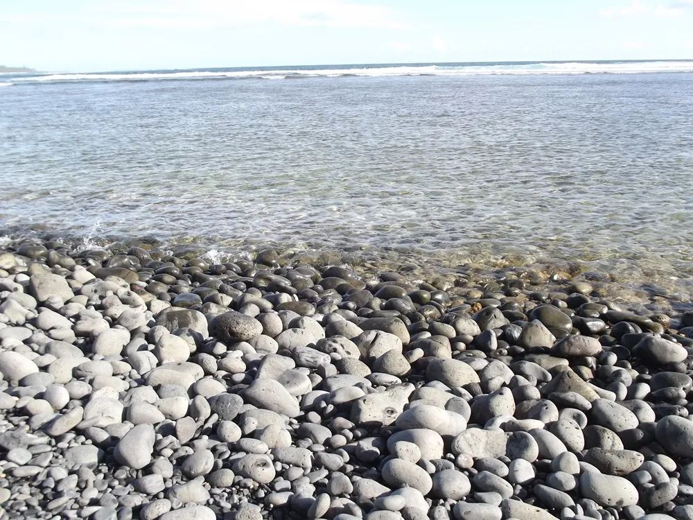 View across the rocky beach towards the open sea at Rivière des Galets.