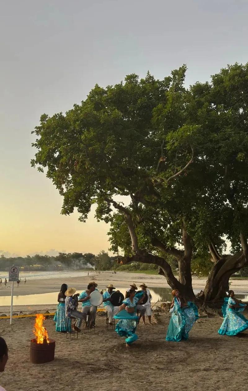 mauritian-sega-dancers-performing-on-the-sand-at-sunset--with-live-percussion--turquoise-costumes-and-a-scenic-beach-backdrop..webp