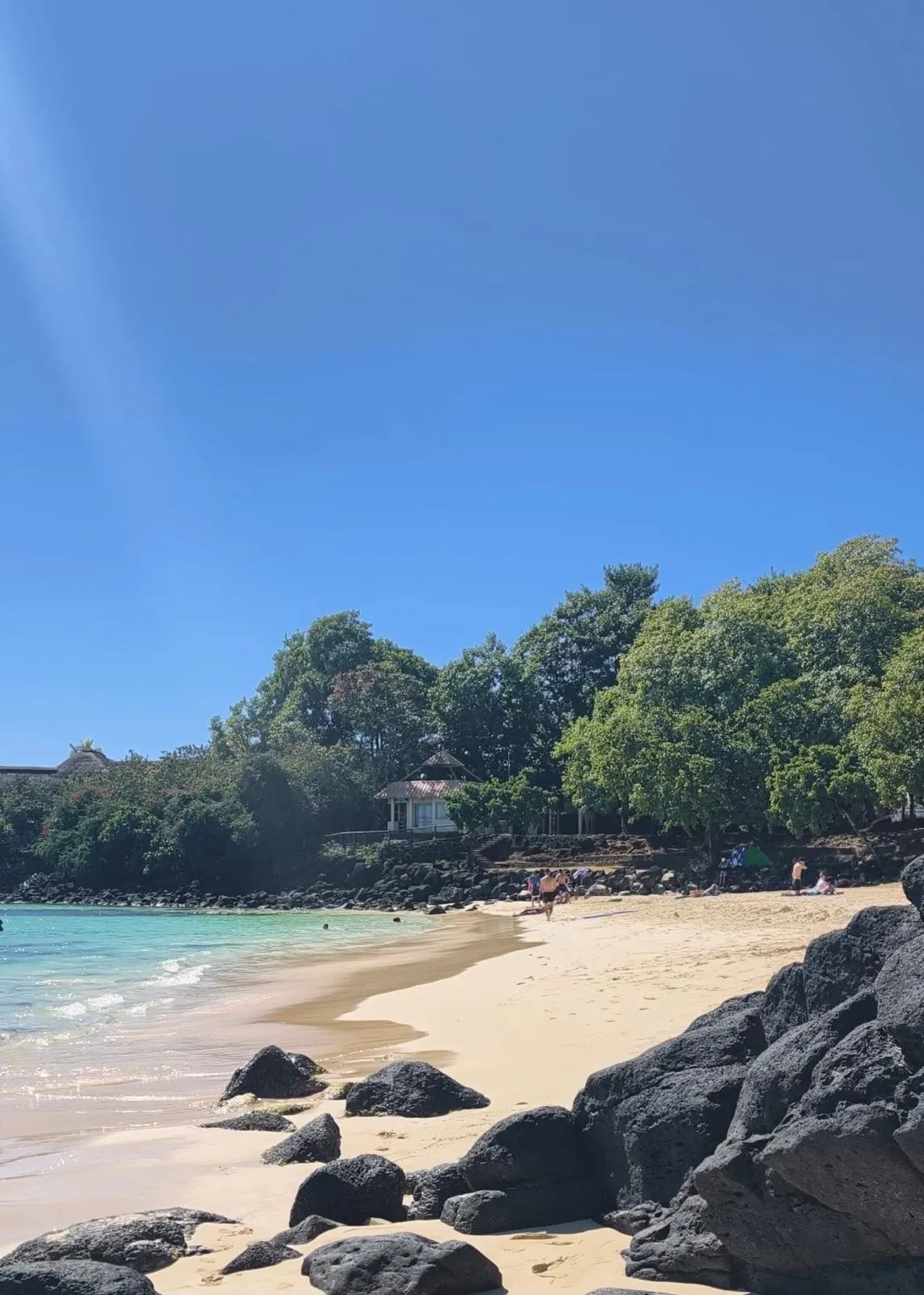 La Cuvette Beach in Grand Baie, Mauritius, with white sand and clear turquoise water.